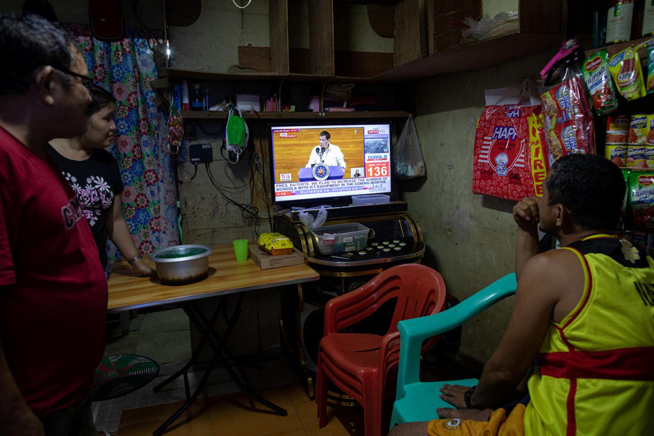 Filipinos watch President Rodrigo Duterte's fifth State of the Nation Address from a television attached on a karaoke inside a home, in Quezon City, Metro Manila, Philippines, July 27, 2020. 