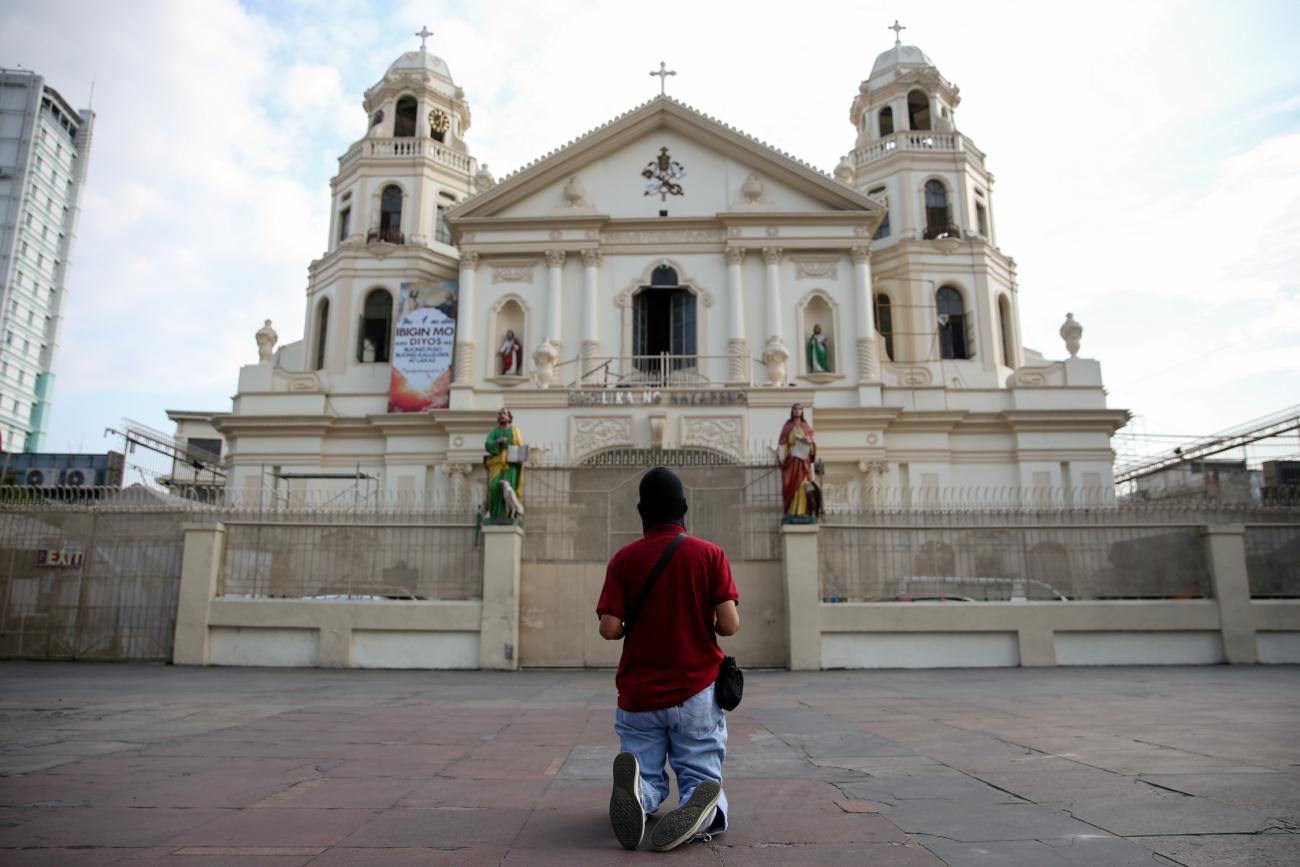 A Filipino Catholic prays outside a closed church on Holy Thursday amid the enforcement of home quarantine to contain COVID-19, in Manila, Philippines, on April 9, 2020.