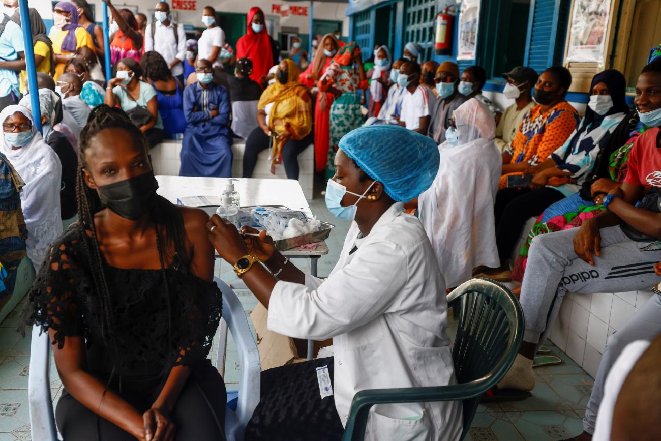 a woman receives a vaccination from a health-care worker.