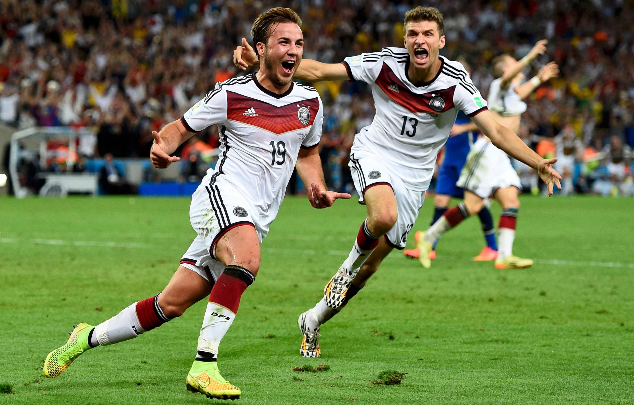 The photo shows two German players running in celebration. 