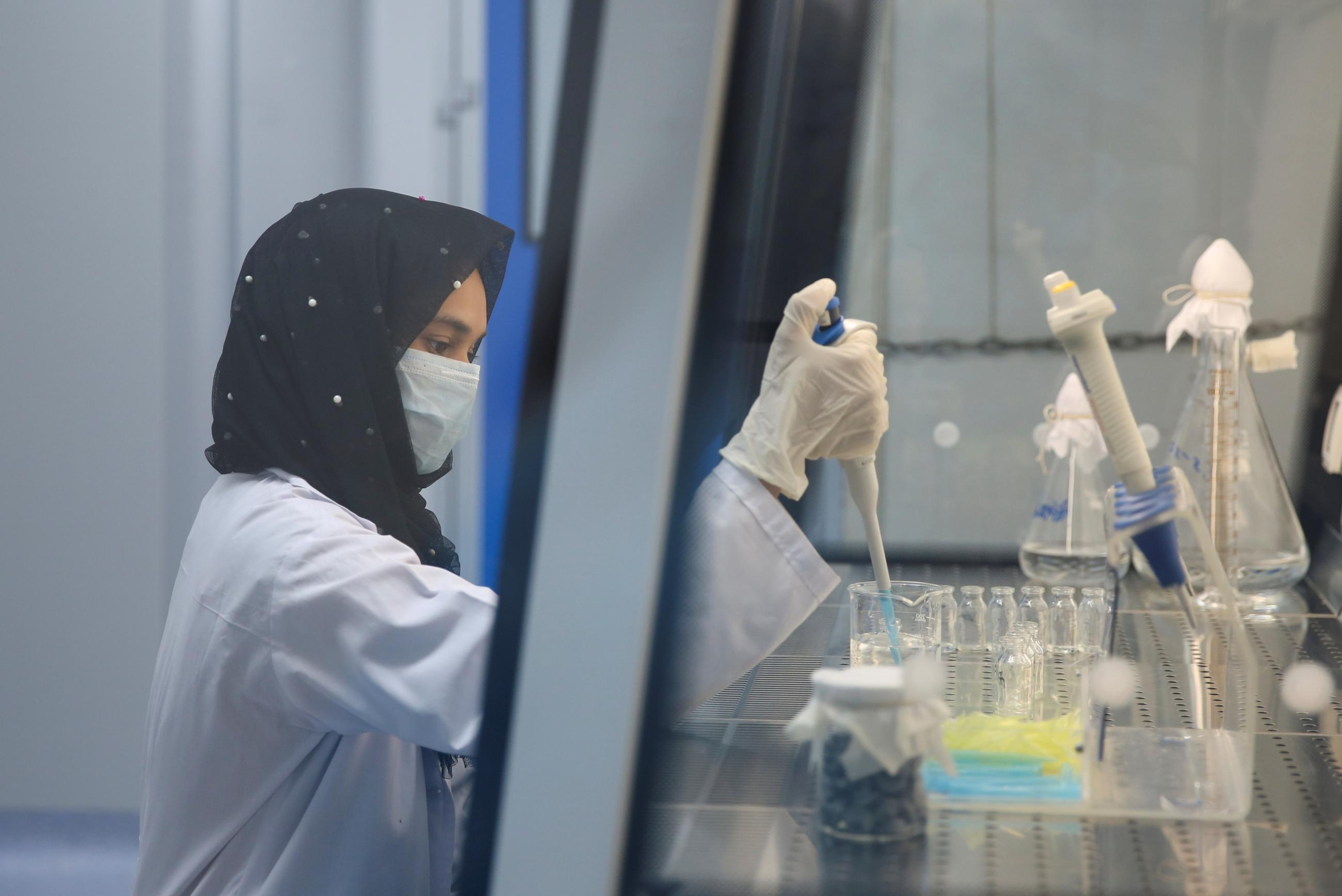 Ayesha Shehzadi, a lab technician, carries out testing procedures for the PakVac COVID-19 vaccine, produced locally at the National Institute of Health in Islamabad, Pakistan, on June 3, 2021.