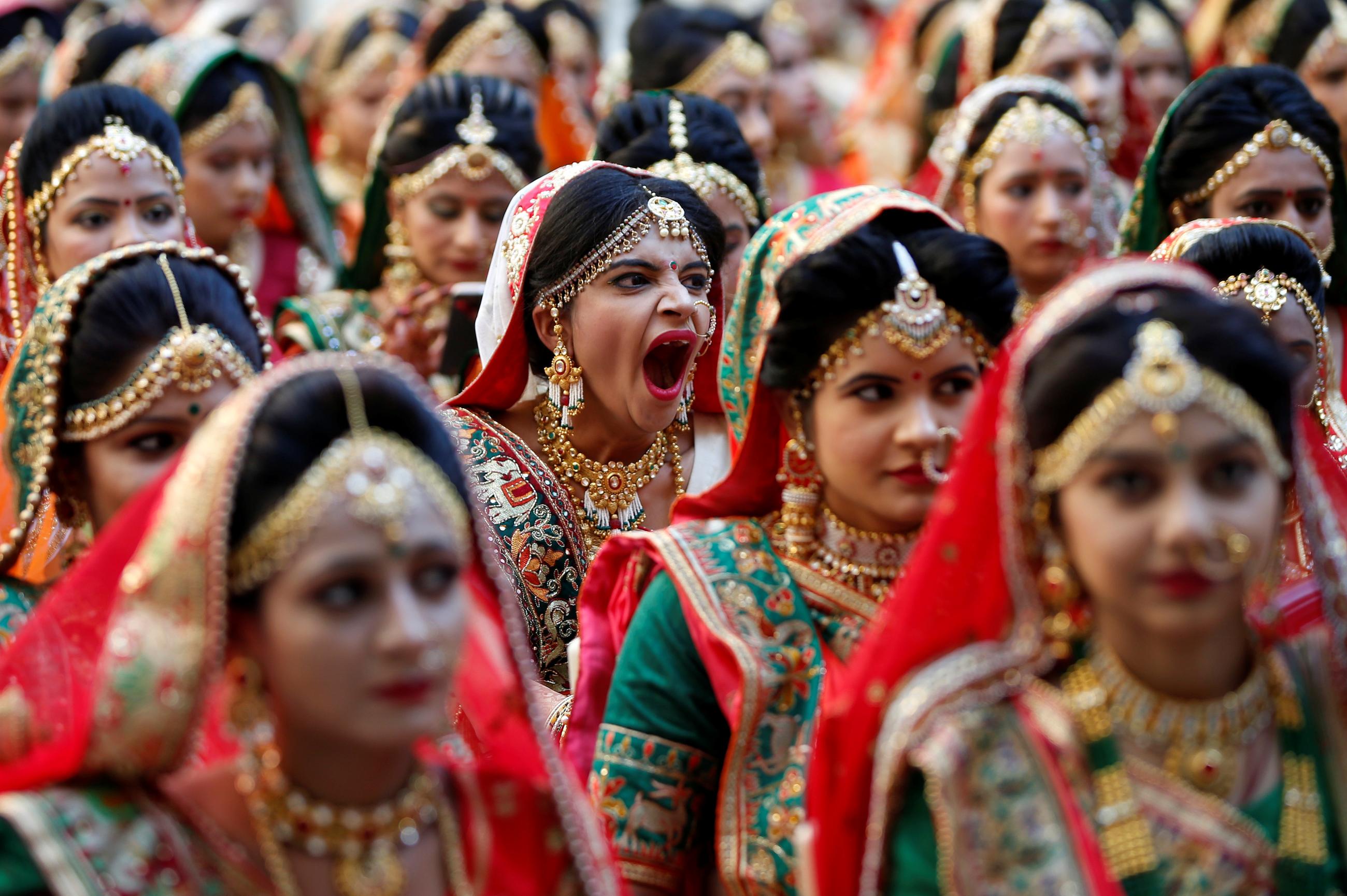 A bride yawns as she and others wait to take their wedding vows during a mass marriage ceremony, organized by a diamond merchant, in which 261 including six Muslim and three Christian couples took their wedding vows, in Surat, Gujarat, India, December 23, 2018.