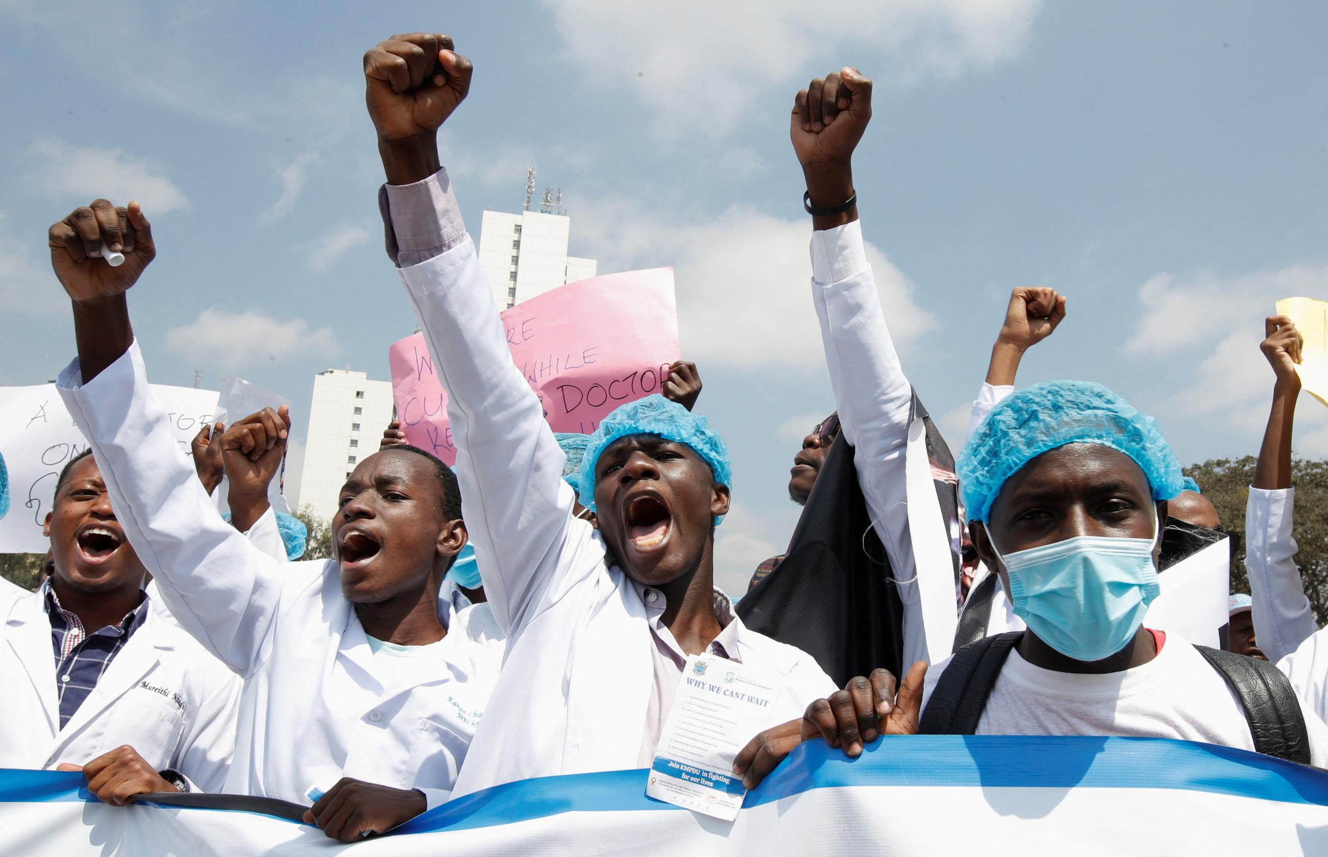 Doctors are seen raising their arms in protest.