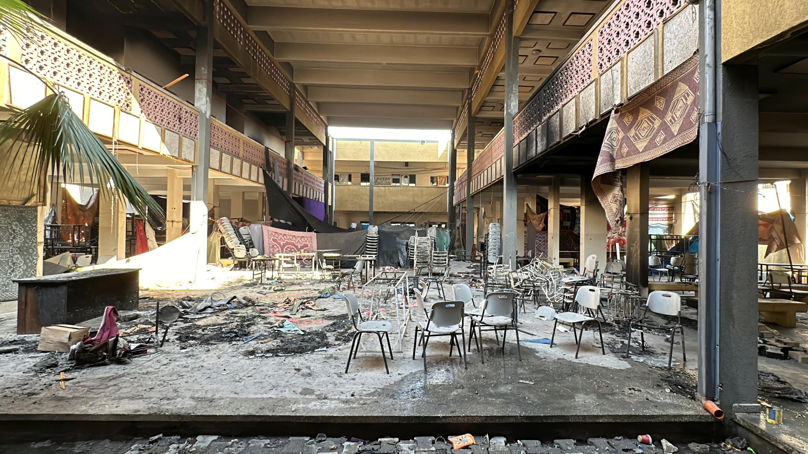 Damaged chairs stand amid debris at Shadia Abu Ghazaleh school following an Israeli raid.