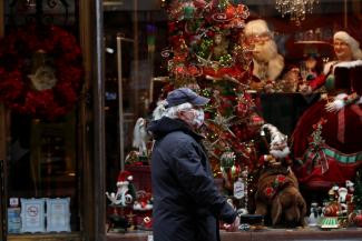 An elderly  man wearing a protective face mask walks in front of a Christmas store display in downtown Budapest, after Hungarian government imposed a nationwide lockdown to contain the spread of the coronavirus disease (COVID-19)