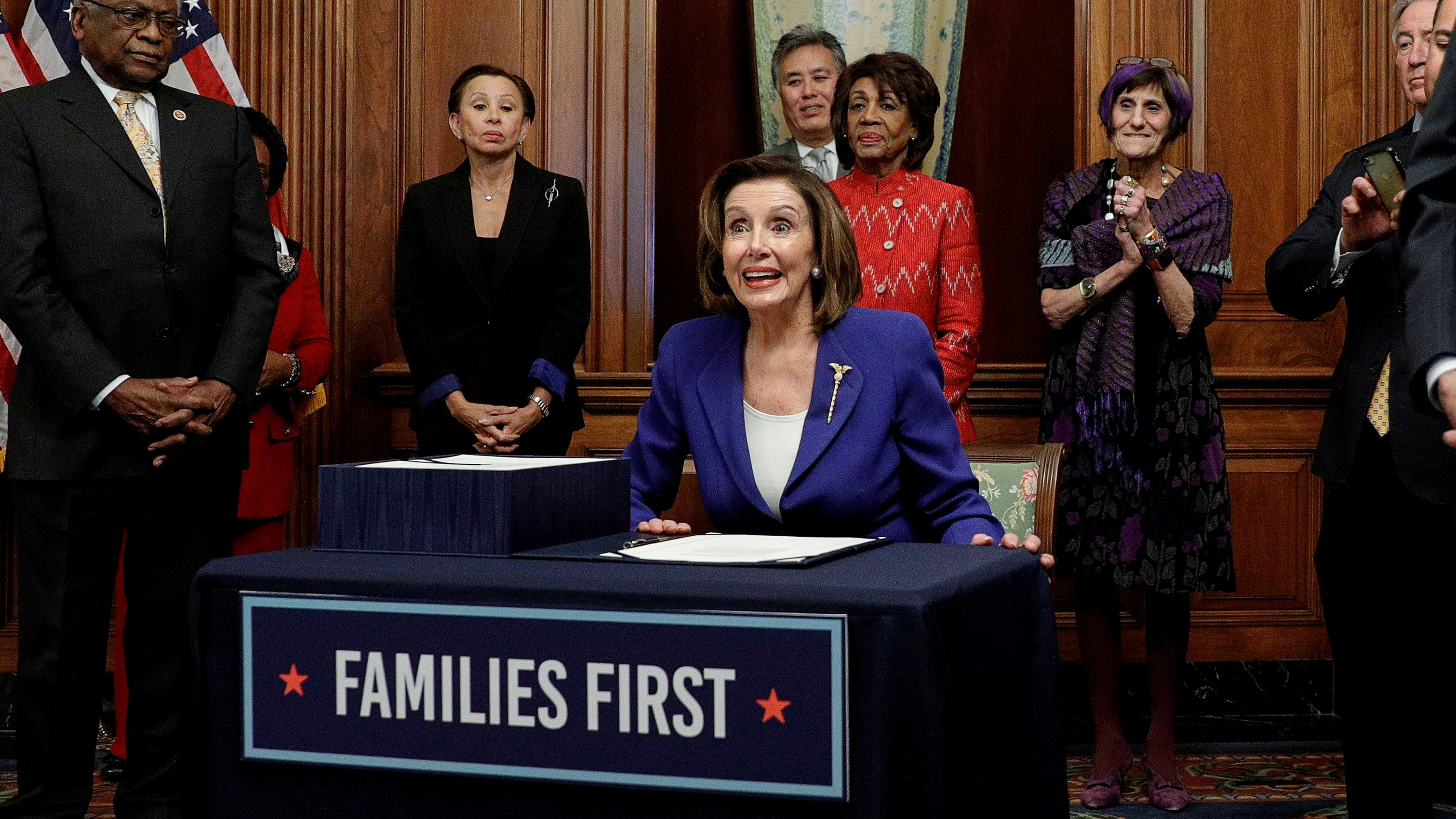 The picture shows the speaker standing at a podium adorned with the words, "FAMILIES FIRST" and surrounded by other politicians. 