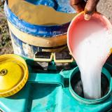 A farmer preparing a mixture of potent chemical pesticides to protect his vegetables. 