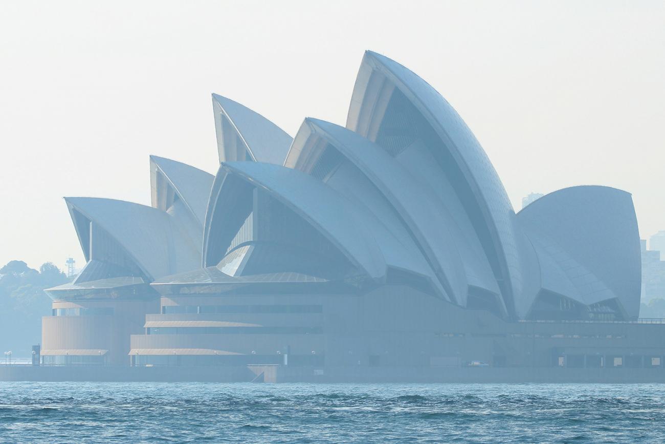 The photo shows the iconic structure with water in between in a blue, blue image filled with smoky air. 