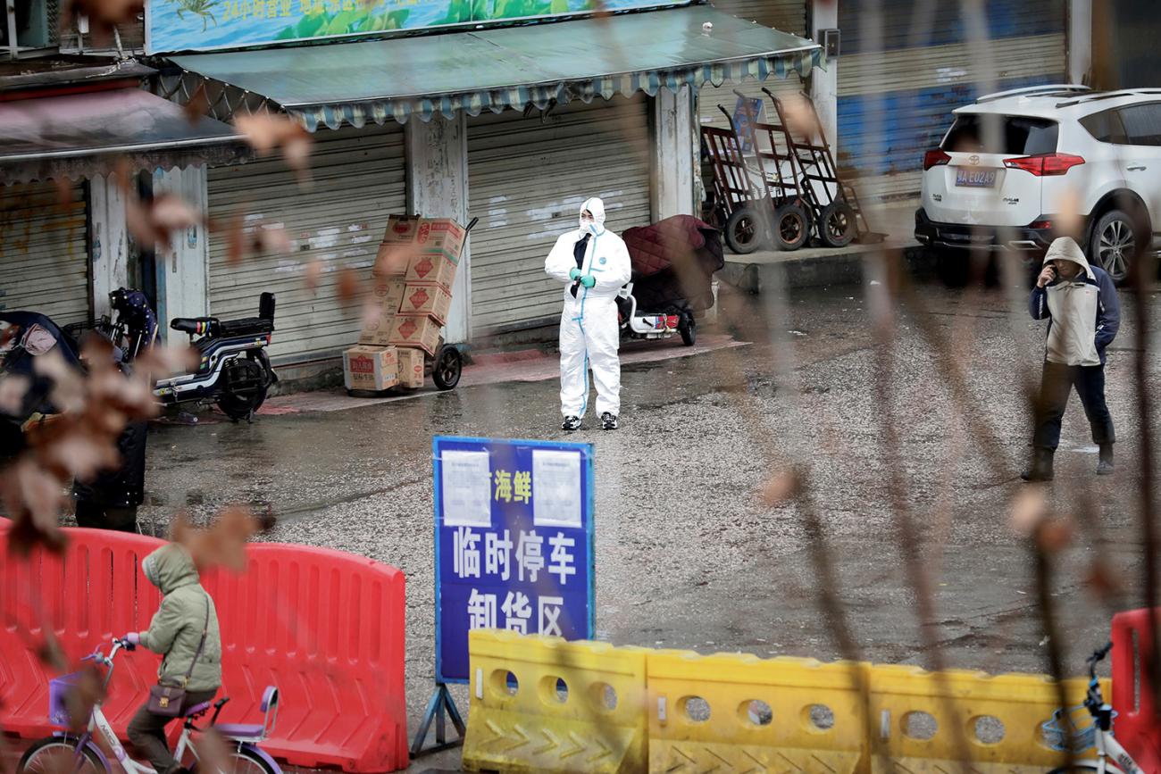  Picture shows a street with a health worker in front of the shuttered market. 