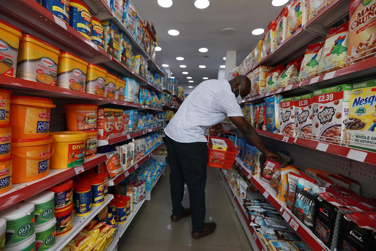 The photo shows a man in a supermarket. 