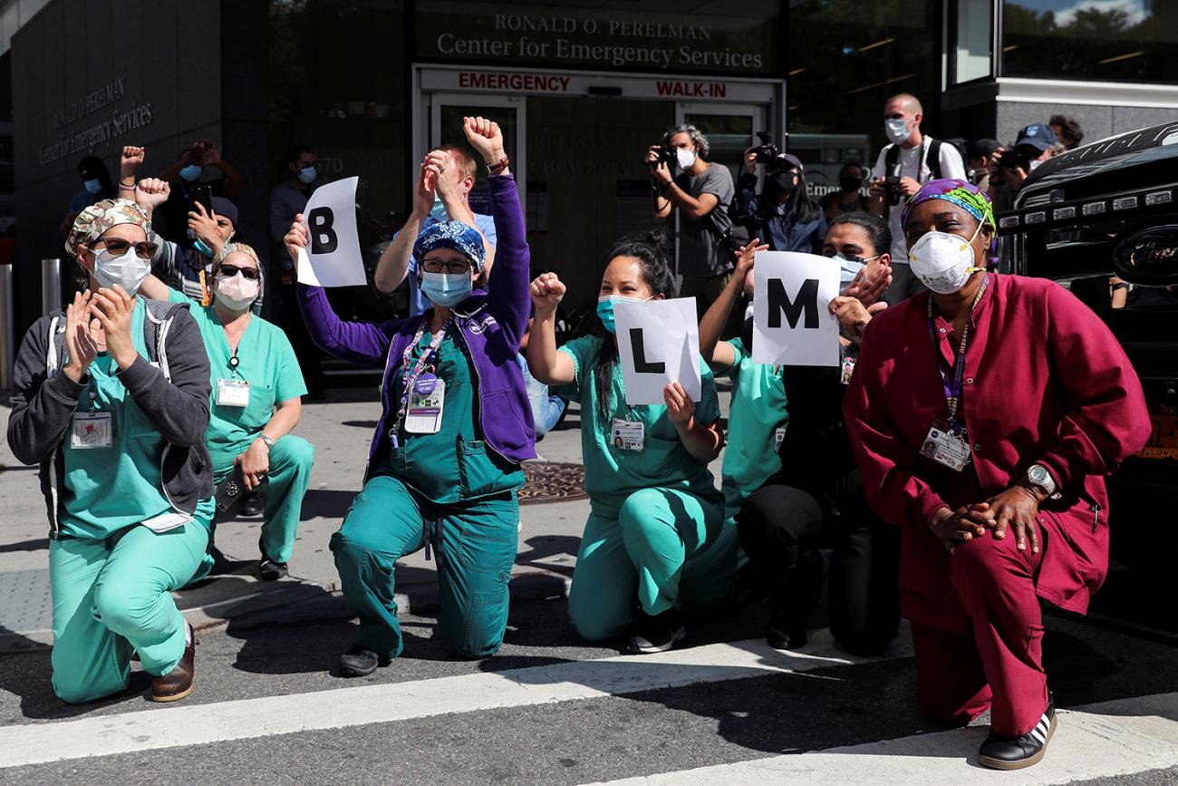 The photo shows a number of health workers taking a knee in protest.