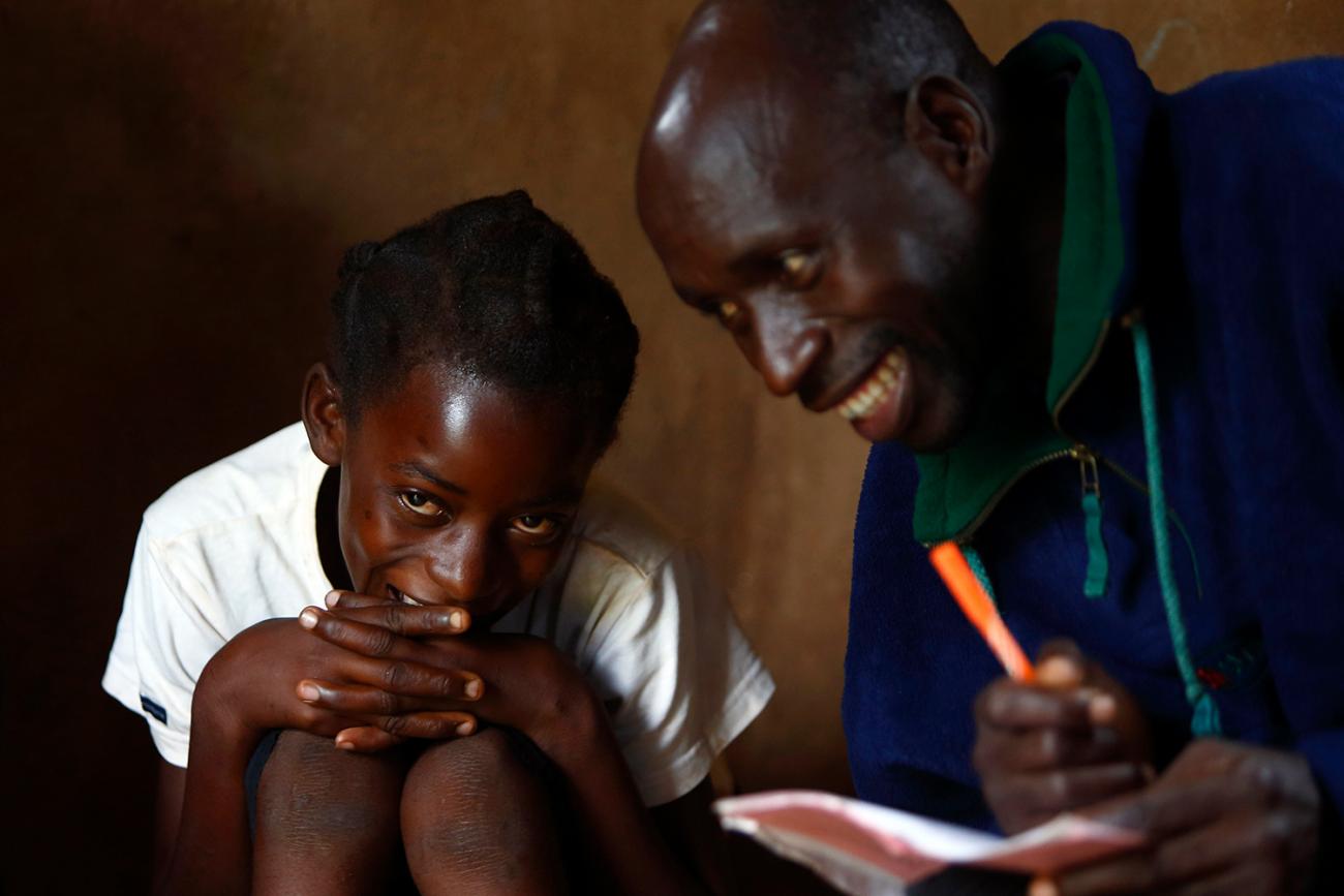 The photo shows the girl and caregiver laughing in an intimate portrait. 