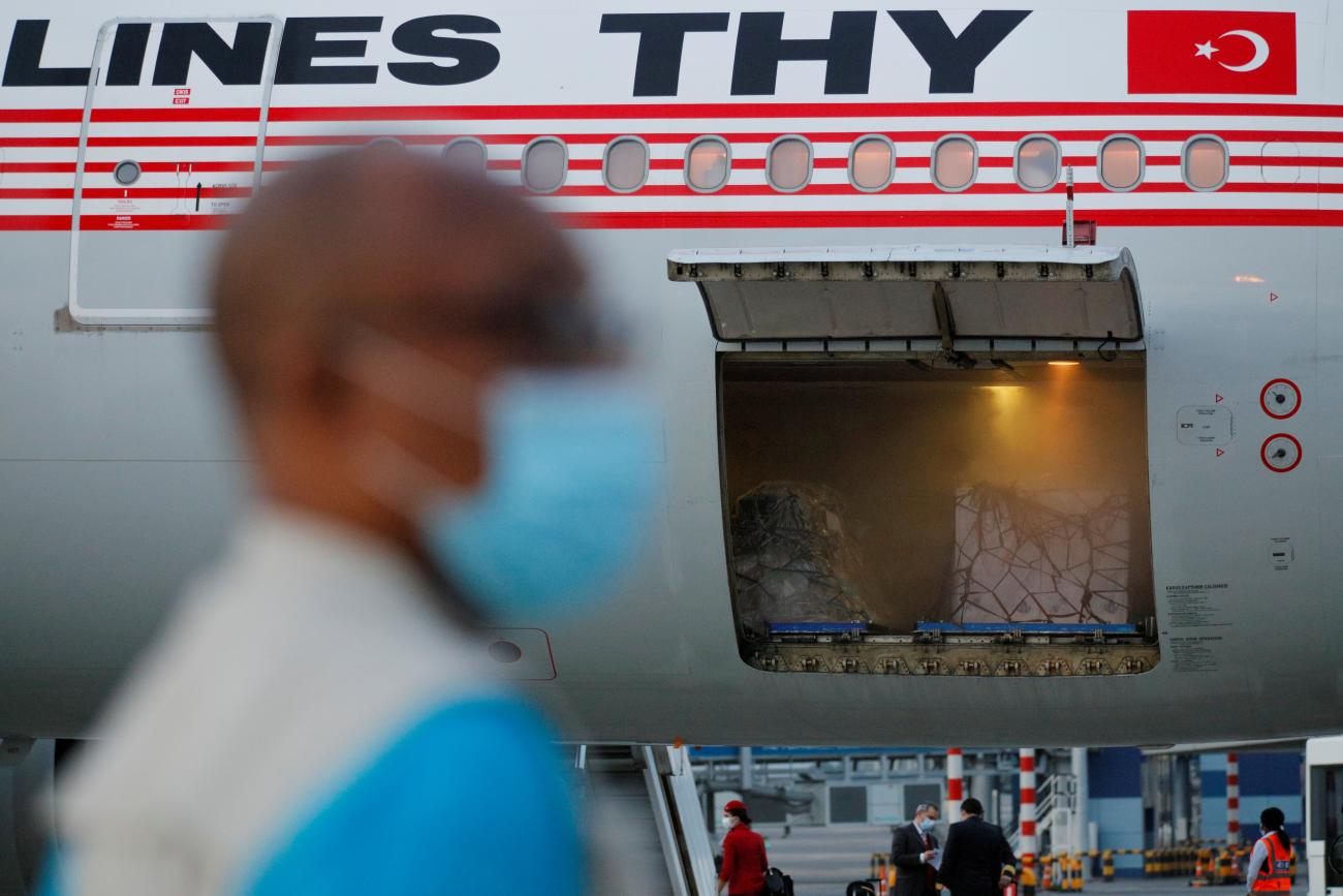 A man can be seen near a plane with 350,000 doses of the Oxford/AstraZeneca COVID-19 vaccine, redeployed from the Democratic Republic of Congo, arrive at the Kotoka International Airport in Accra, Ghana, on May 7, 2021.