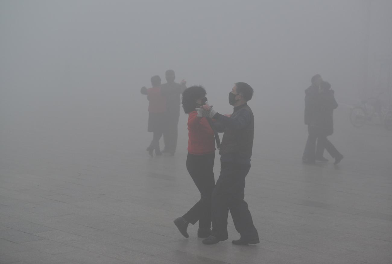 Pairs of masked dancers glide through heavy smog on a polluted day in Fuyang, Anhui province, China, on January 3, 2017.