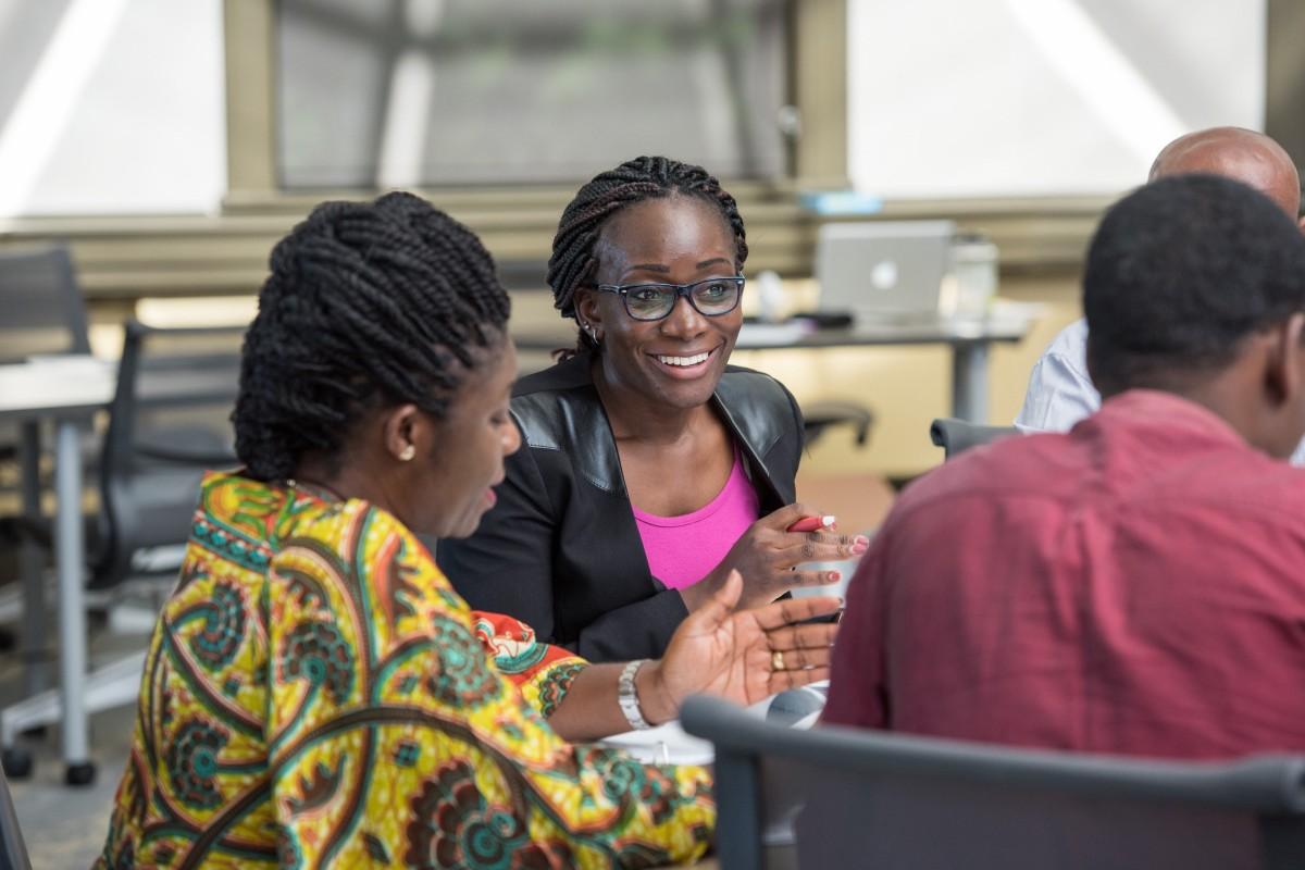 Dr. Liz Wangia sits at a table with other African health leaders during a professional development program in 2017