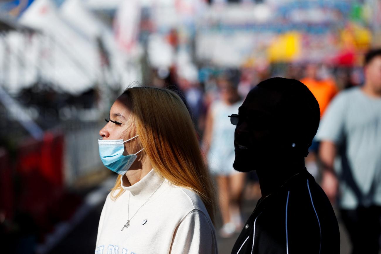 People with and without masks attend the Florida State Fair at the Florida State Fairgrounds as the stealth omicron variant spreads, in Tampa, Florida, on February 11, 2022. 