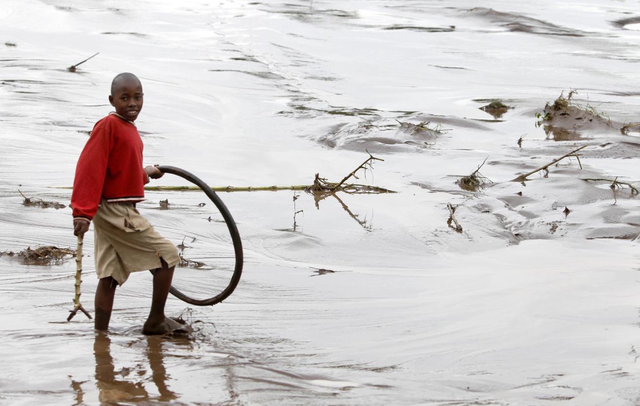 A boy wades through floodwaters after heavy rains in Bududa village.