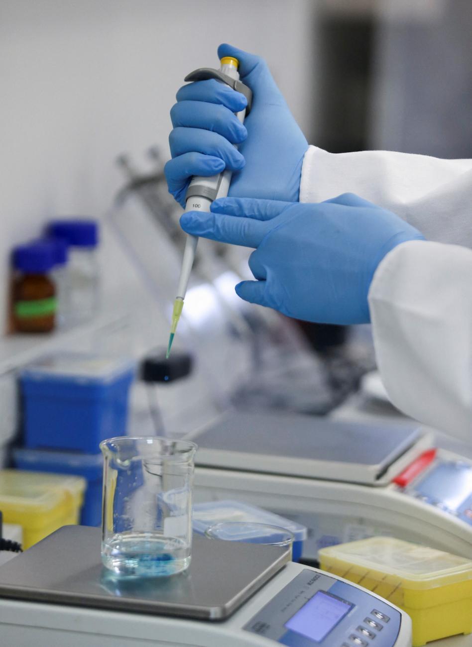A production scientist works with samples in a WHO-backed mRNA vaccine hub.