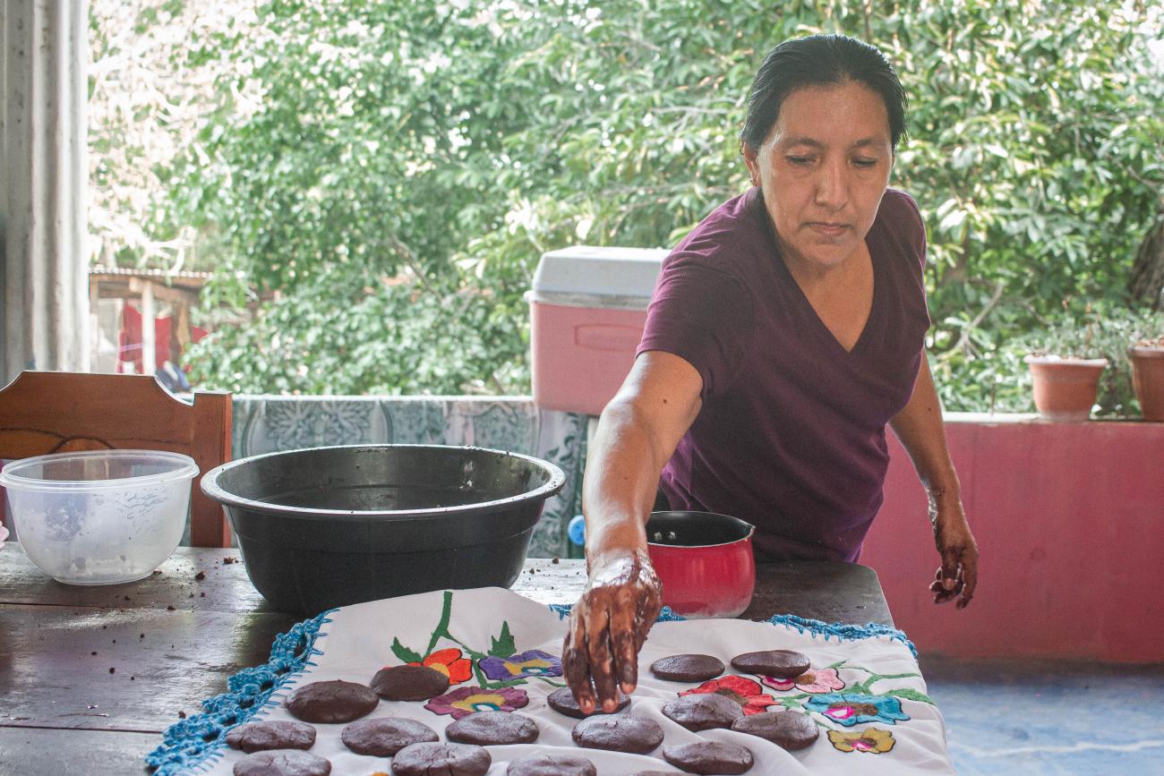 A community woman from La Técnica shows tourists how cocoa is processed.