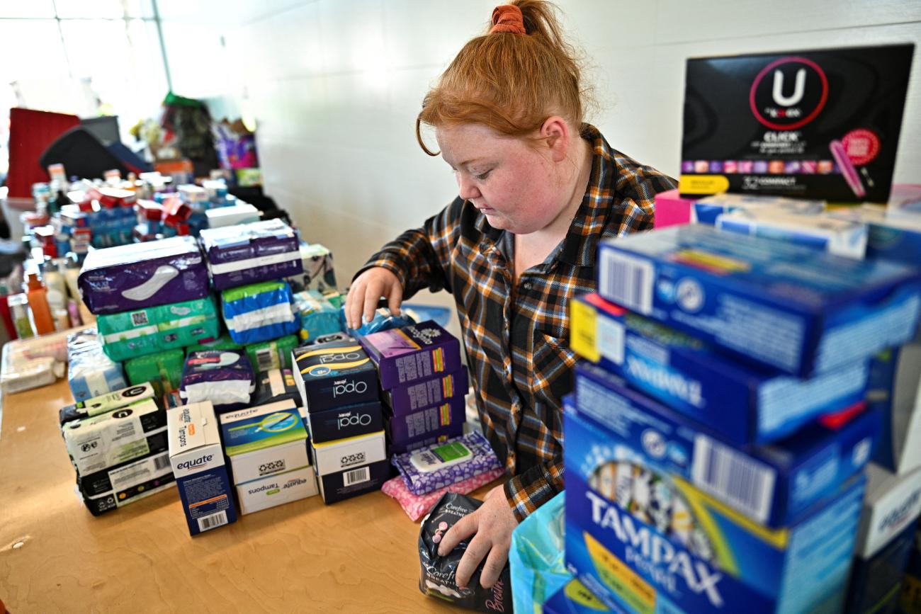 A Sullivan resident sorts through menstrual products at the emergency supply depot at the Sullivan Civic Center two days after a tornado hit Sullivan, Indiana U.S. April 2, 2023.