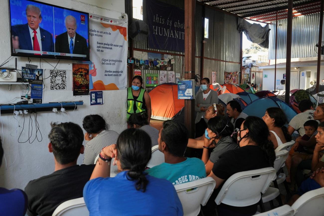 Migrants watch the first debate between President Joe Biden and former U.S. President Donald Trump, at the Juventud 2000 migrant shelter, in Tijuana, Mexico June 27, 2024.