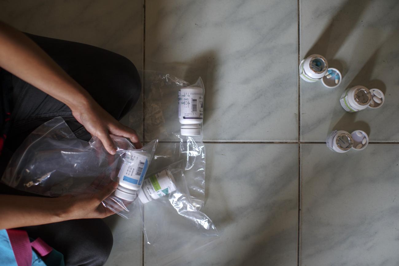 A 39-year-old Burmese migrant living with HIV shows her antiretroviral drugs to a journalist during an interview.