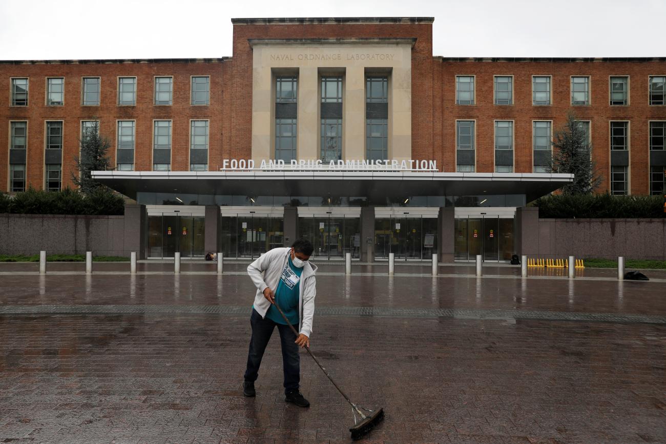 A worker sweeps outside of the Food and Drug Administration headquarters.