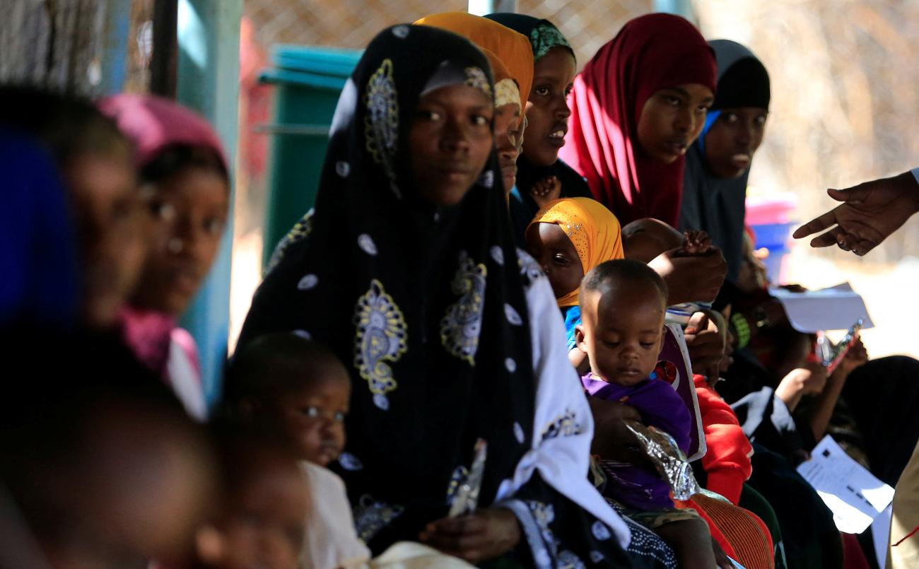 Somali refugee women carry their children as they wait to be enrolled in the nutrition program in the Hagadera refugee camp in Dadaab.