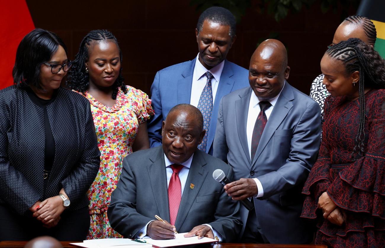 South Africa's President Cyril Ramaphosa gestures as he signs into law a national health bill that aims to provide universal coverage to South Africans.