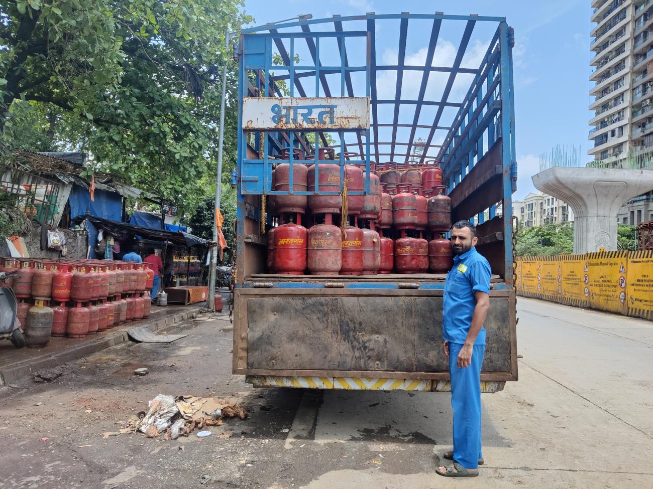 A man is seen standing next to a truck carrying gas cylinders in Mumbai, India, June 12, 2024.