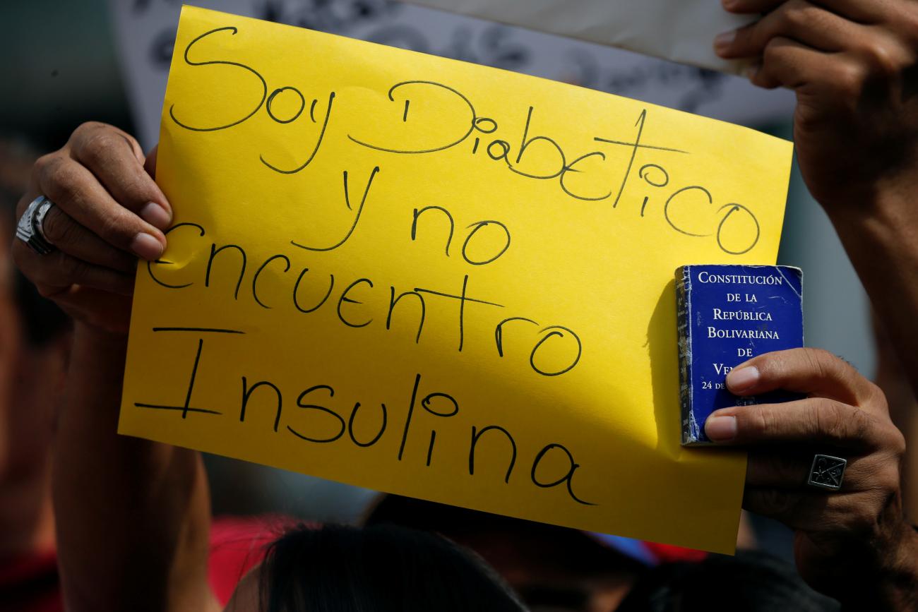 An opposition supporter holds a placard that reads: "I am diabetic and can't find insulin" and a copy of the Venezuelan constitution, during a protest due to the lack of medicines and to demand a referendum to remove President Nicolas Maduro in Caracas, Venezuela, August 2, 2016.