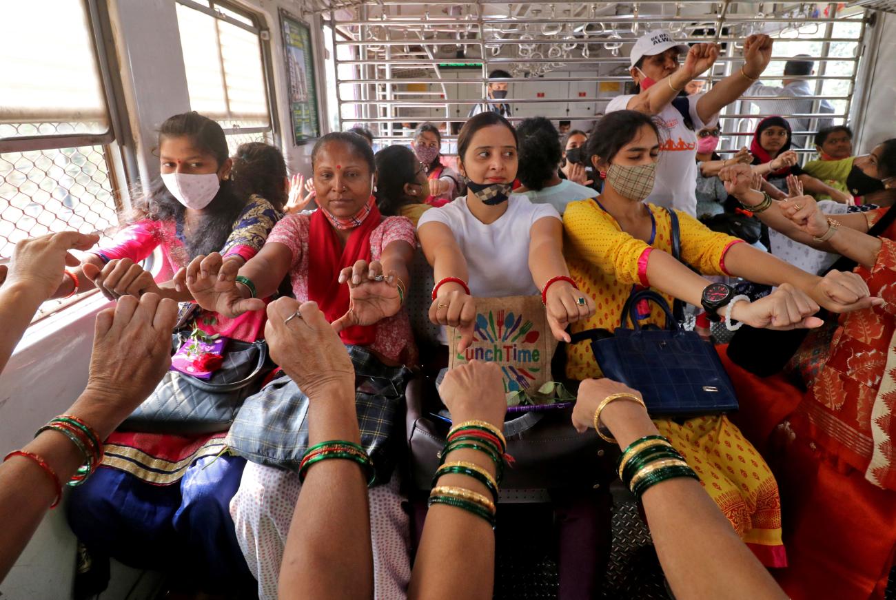 Women perform yoga in a local train on International Women's Day.