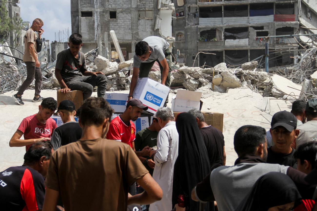 Palestinians gather to receive aid, including food supplies provided by World Food Program, outside a United Nations distribution center.