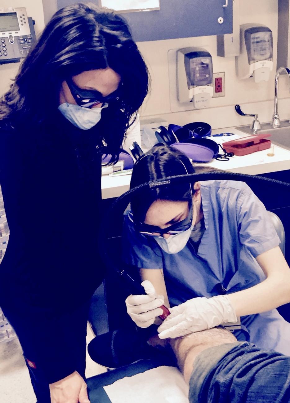 Shadi Kourosh, from the Harvard Dermatology program pro-bono laser clinic, teaches tattoo removal to young physicians in training in this community service program.