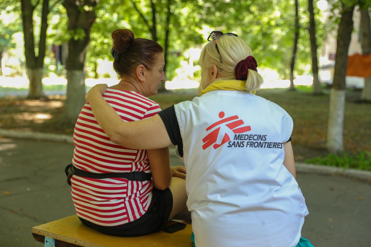 An internally displaced person (IDP) from the Kherson region speaks with a Doctors without Borders psychologist in an IDP center in Kryvyi Rih, Ukraine about the recent death of her son, July 28, 2022.  