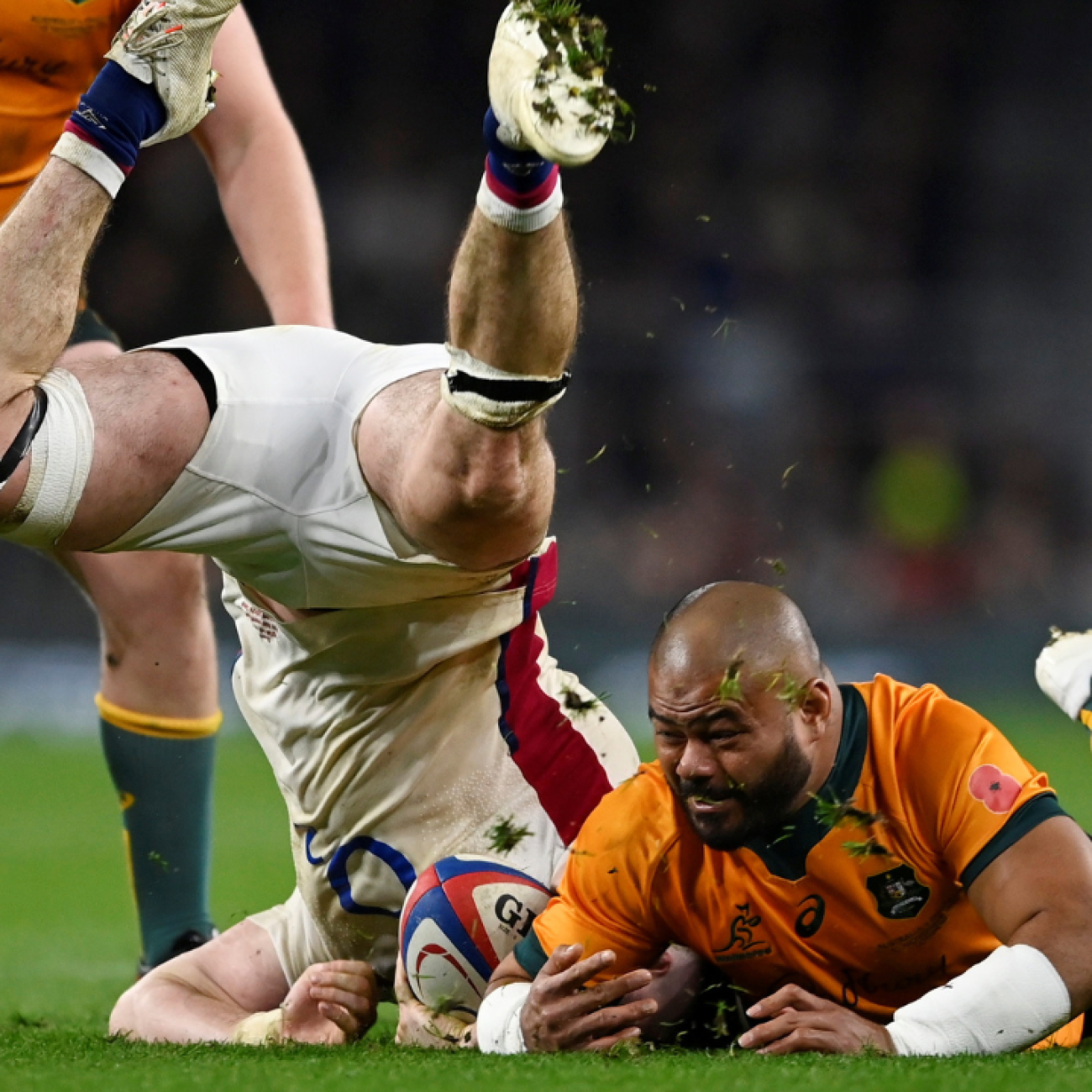 England's Tom Curry tumbles head down over Australia's Tolu Latu on the rugby pitch at Twickenham Stadium, in London, Uk, on November 13, 2021.