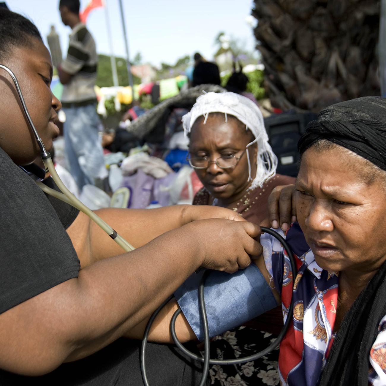 A nurse takes a woman's blood pressure.