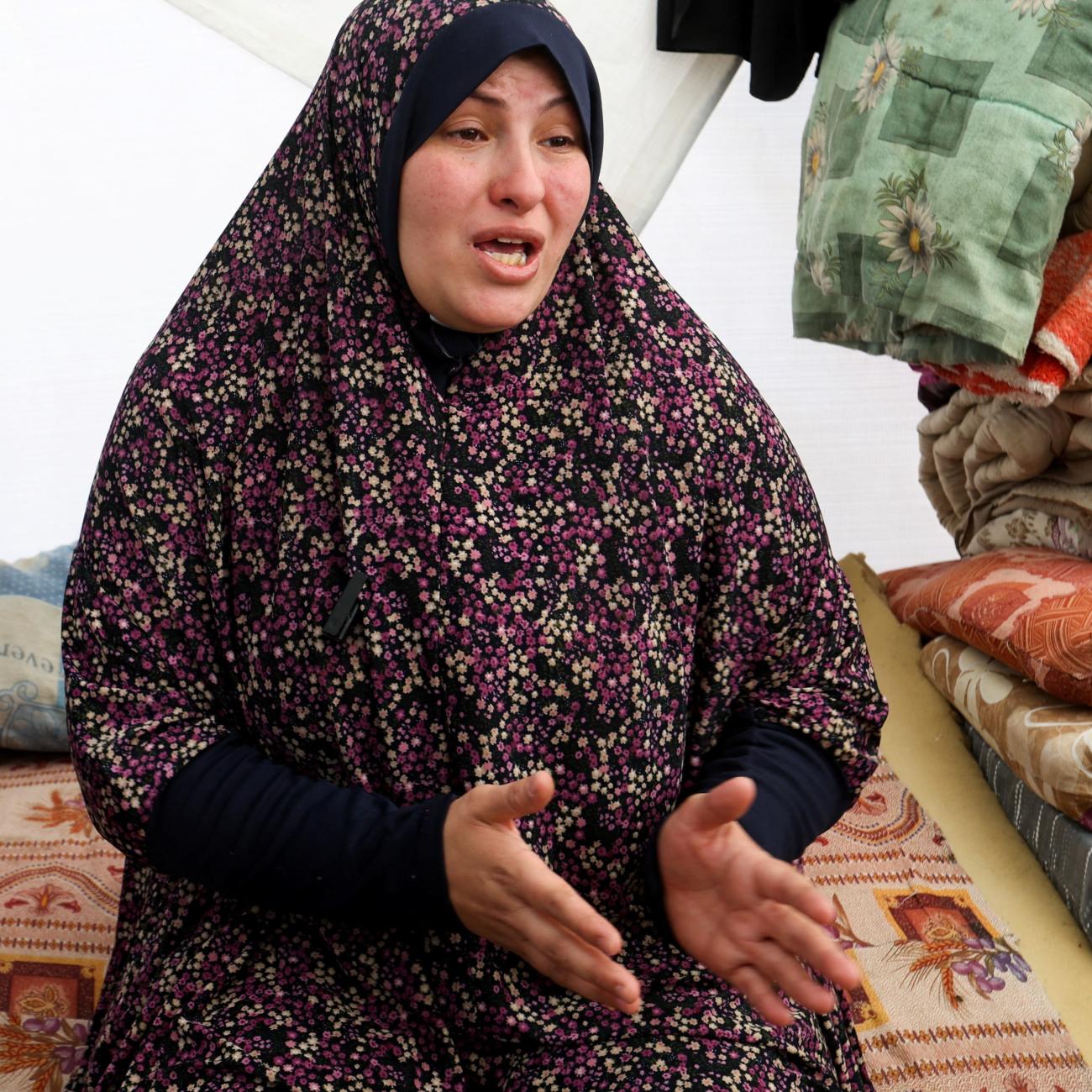 A displaced pregnant Palestinian woman speaks in a tent.