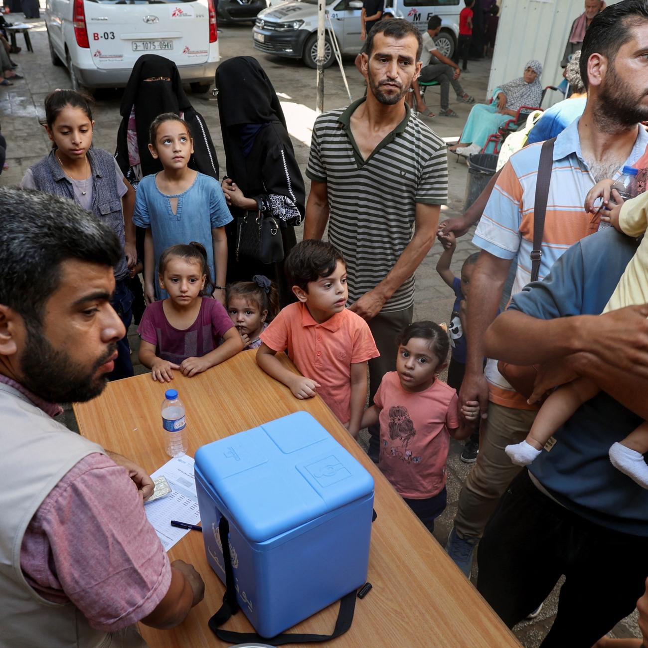 Palestinian children, accompanied by parents, wait to be vaccinated against polio.