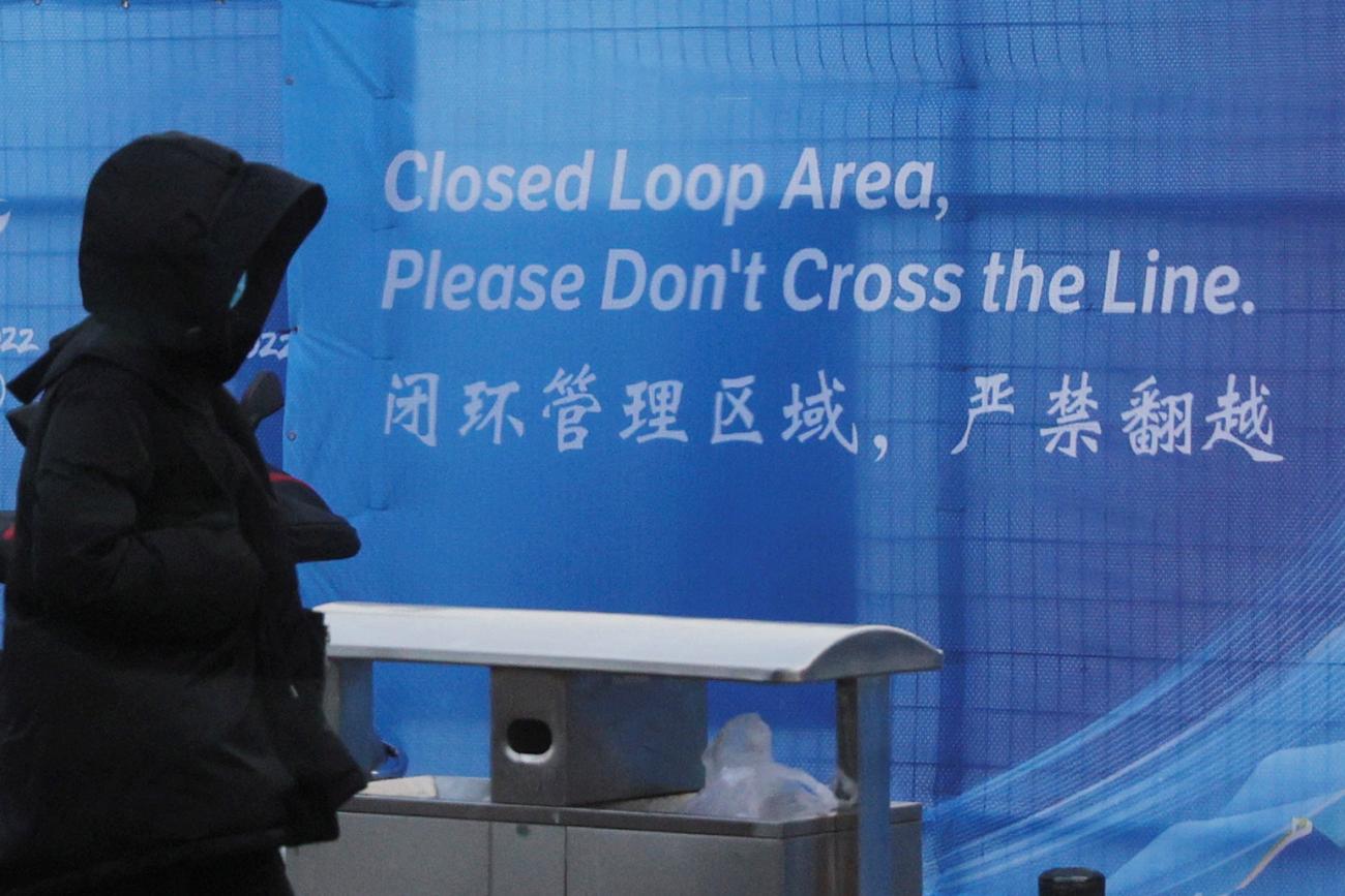  pedestrian passes a sign marking the barrier of the "Closed Loop," a precaution against the coronavirus disease (COVID-19) ahead of the Beijing 2022 Winter Olympics in Beijing, China, January 30, 2022.