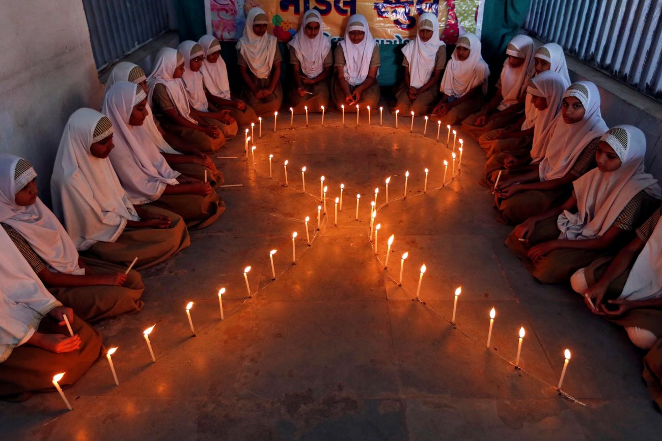 School girls light candles in the shape of a ribbon during a HIV/AIDS awareness campaign ahead of World Aids Day, in Ahmedabad, India November 30, 2016.