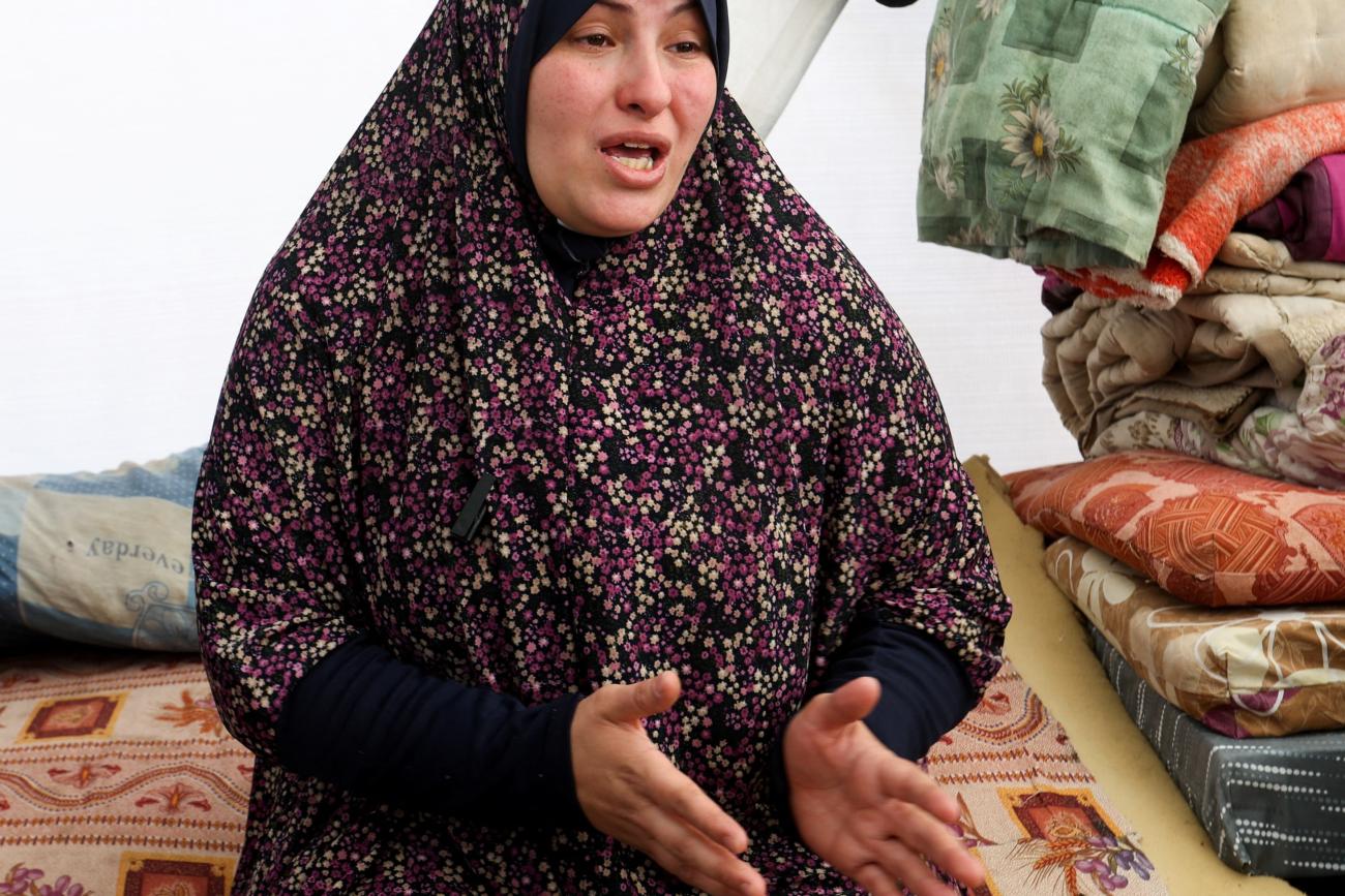 A displaced pregnant Palestinian woman speaks in a tent.