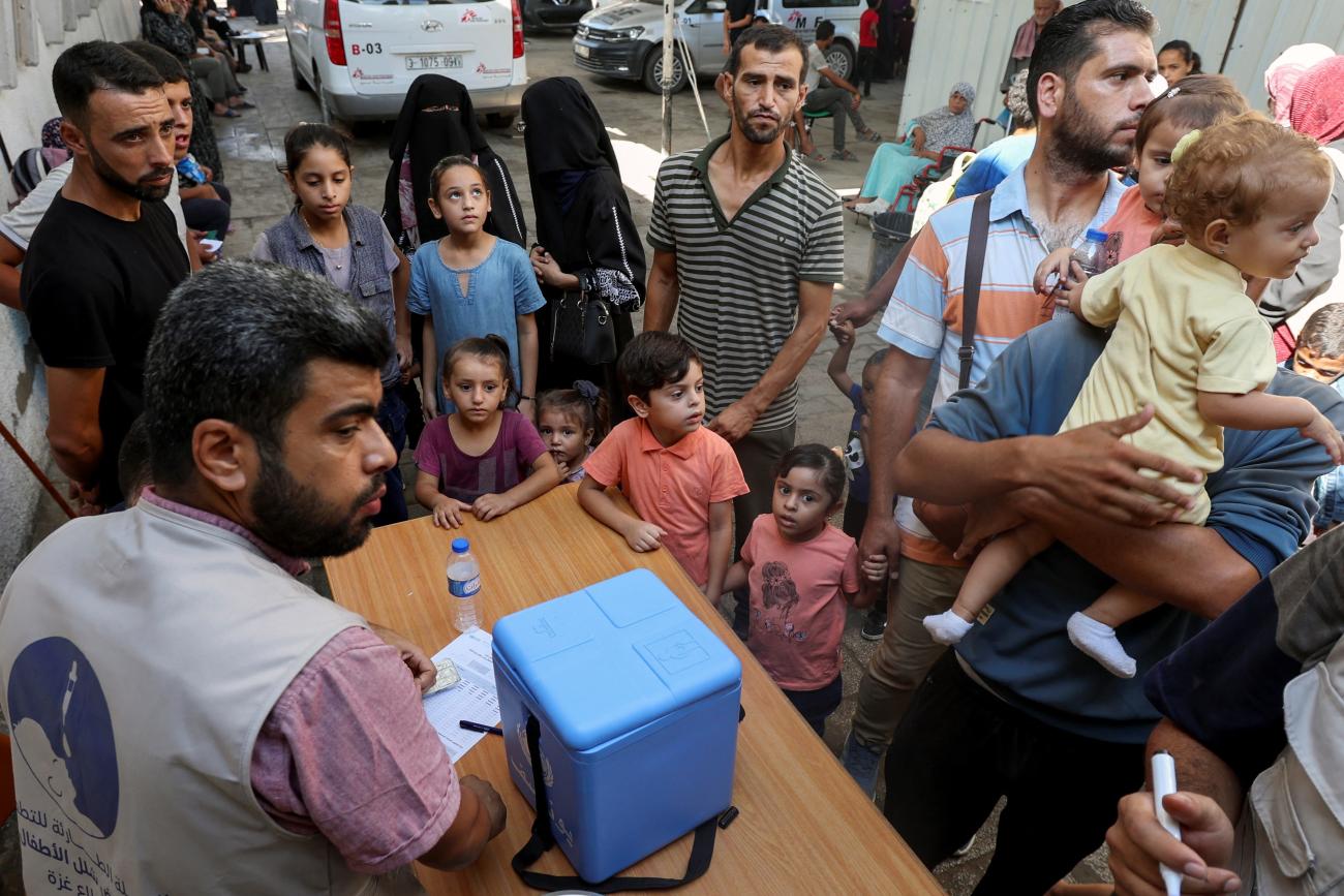 Palestinian children, accompanied by parents, wait to be vaccinated against polio.