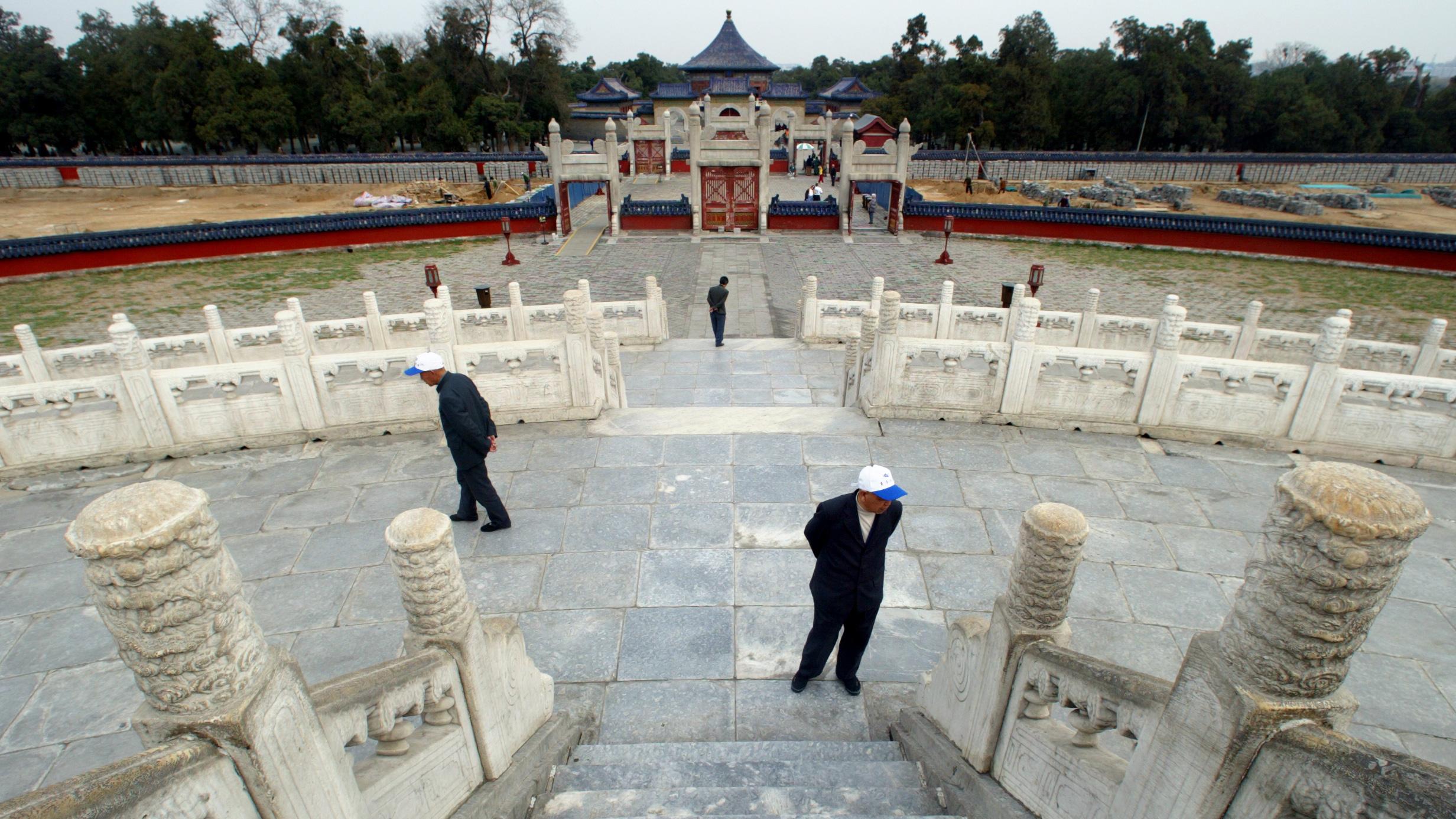 The image shows a stunning old structure from Chinese history with just a few lone tourists walking about. 