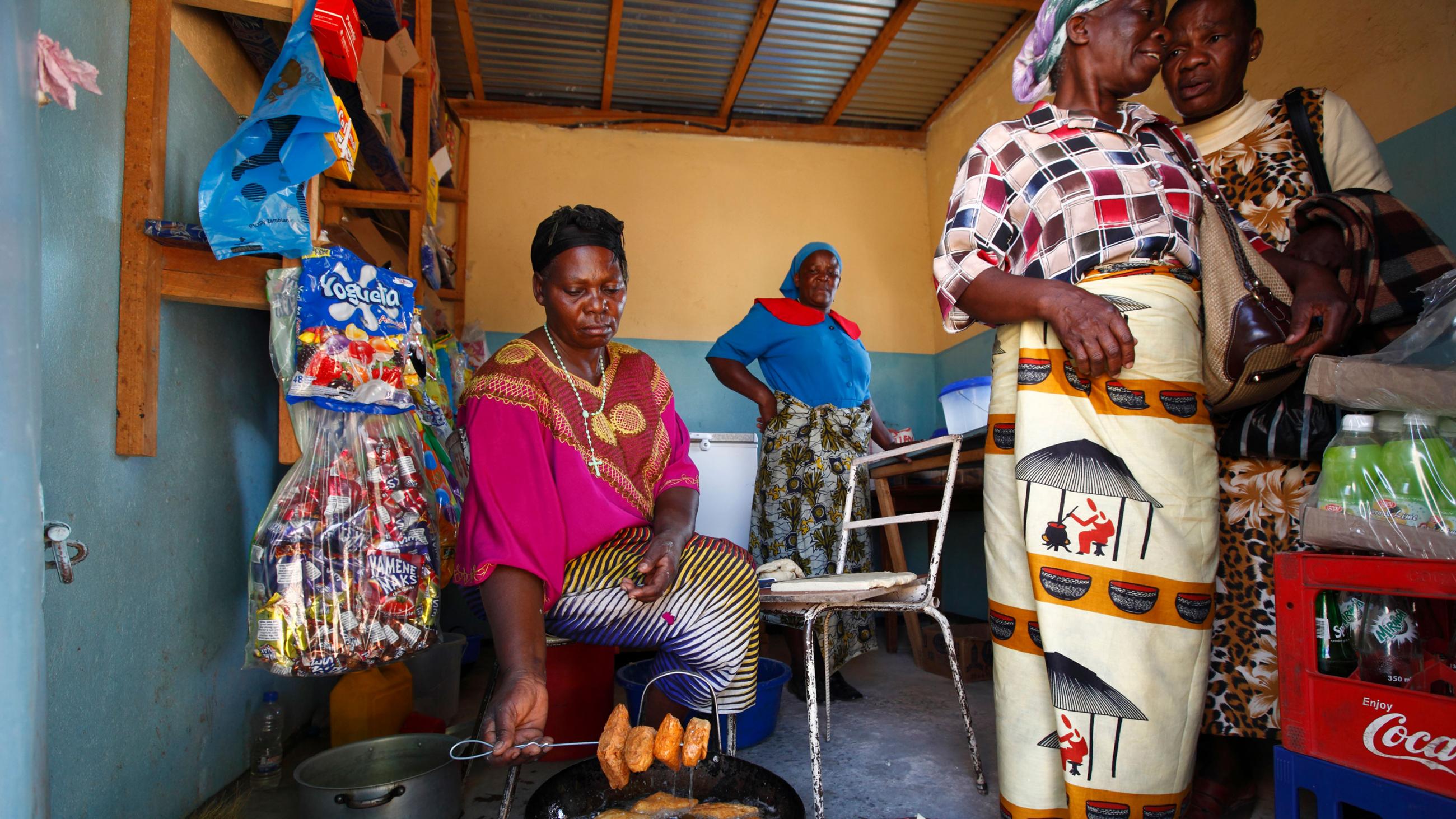 The picture shows the caregivers in a small room frying food. 