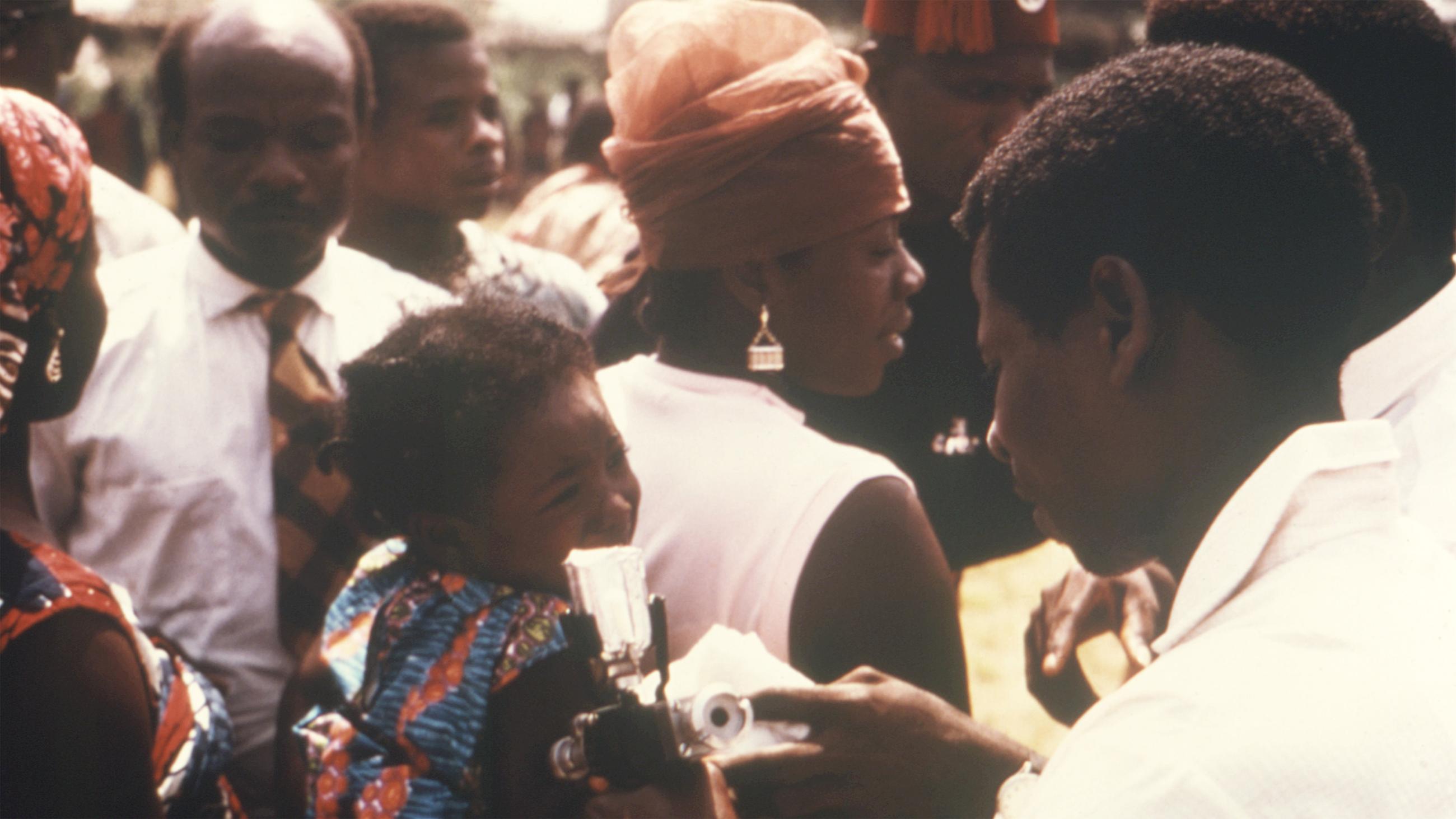 The photo shows a crowd gathered around the girl and the technician. 