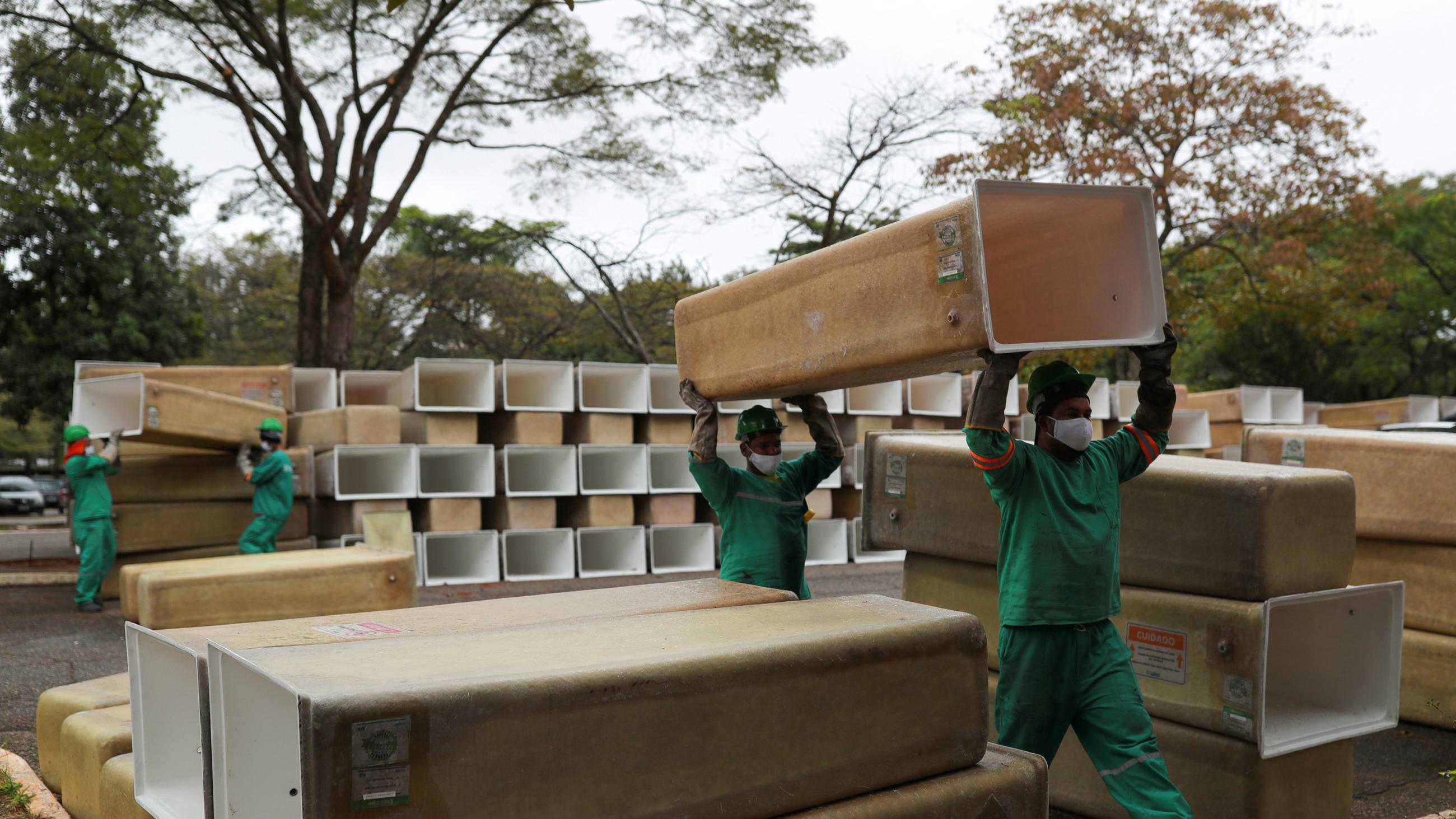 The image shows several workers amid a huge stack of boxes. 