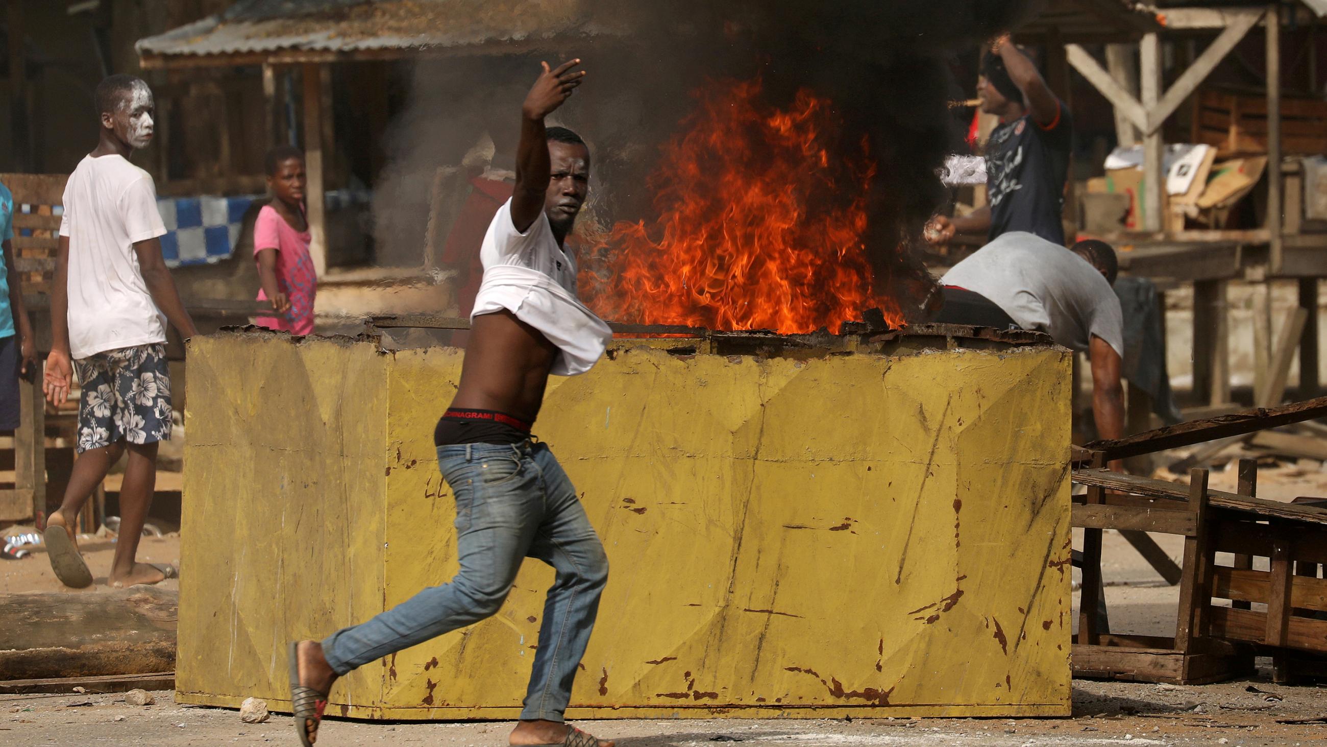 This is a powerful photo showing a protester shouting at the camera as fires rage in the background. 