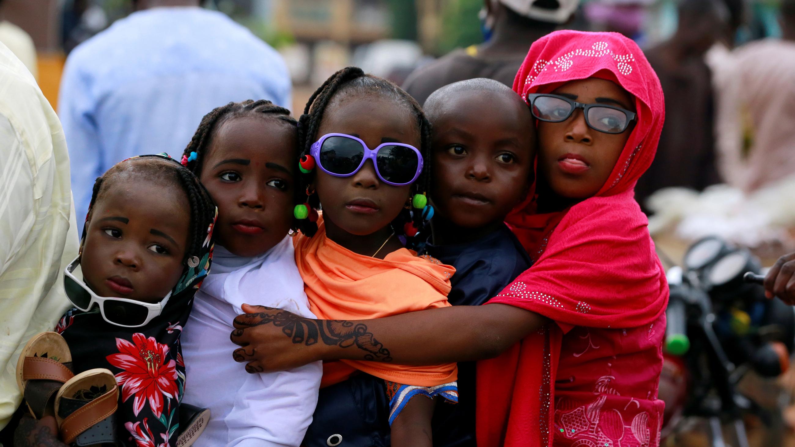 The photo shows four children crammed together on a bike. 