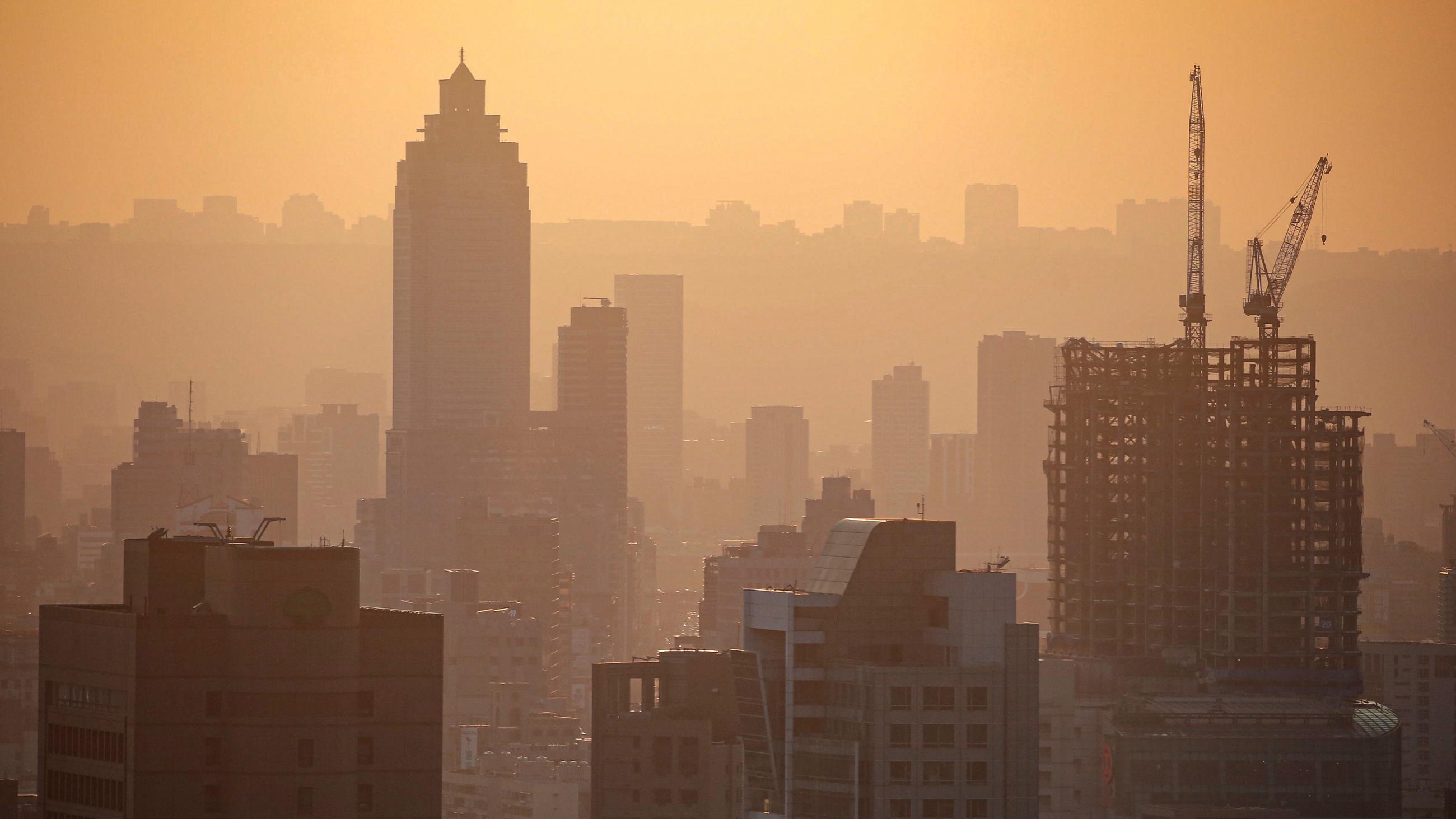 Photo shows a stunning spring sunset over the city, all orange and aglow. 